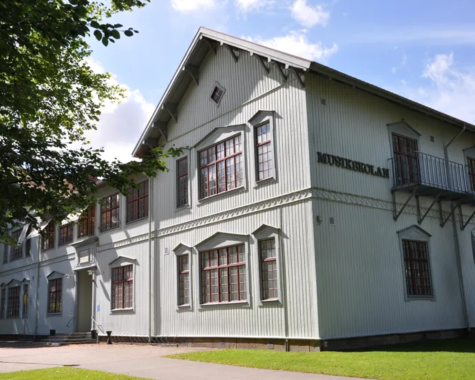 En stor vit byggnad som ligger på ett grönskande fält.