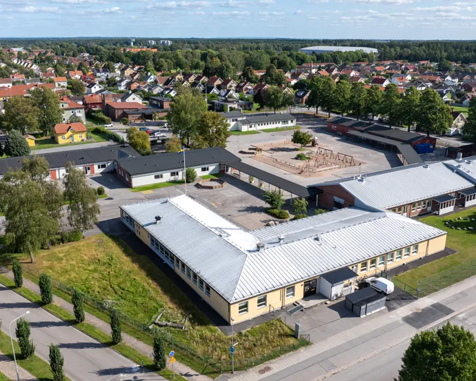 En flygbild av en skolbyggnad med en parkeringsplats.