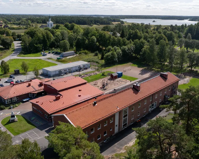 En flygbild av en skolbyggnad omgiven av träd.