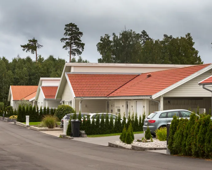 En rad med hus med bilar parkerade framför dem.